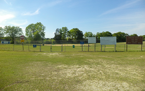 Open recreation area and fenced park grounds behind the community center in Georgetown, Quitman County, Georgia