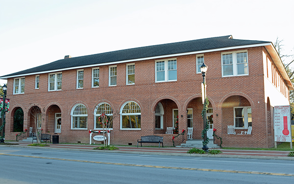 Historic brick Glennwanis Hotel with arched windows and downtown streetscape in Glennville, Georgia