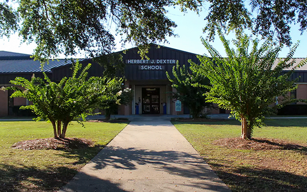 Herbert J. Dexter Elementary School in Chattahoochee County, Georgia, showing the entrance, walkway, and landscaped campus grounds.