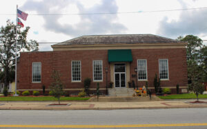 Jesup City Hall in Jesup, Georgia, a single-story red-brick civic building with a flag and landscaped entrance