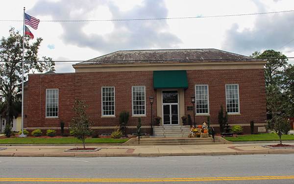 Jesup City Hall in Jesup, Georgia, a
single-story red-brick civic building with a
flag and landscaped entrance