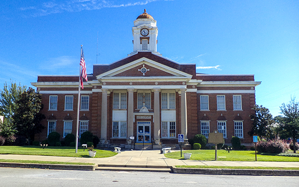Lee County Courthouse with white columns and a clock tower in Leesburg, Georgia