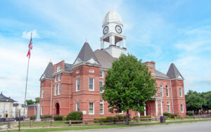 Historic red-brick Macon County Courthouse with clock tower in Oglethorpe, Georgia