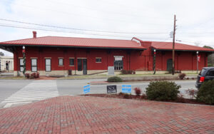 Historic red-brick Montezuma Depot beside a paved downtown plaza in Macon County, Georgia
