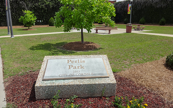 Landscaped grounds with benches and picnic tables at Perlis Park in Cordele, Georgia