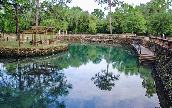 Clear blue spring water and landscaped walkways at Radium Springs Gardens in Albany, Georgia