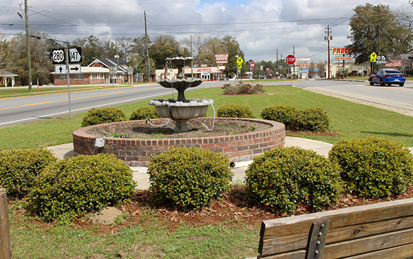Fountain, bench and landscaped planting beds at Reidsville Garden Club Park in Tattnall County, Georgia