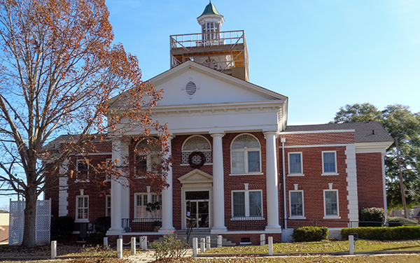 Historic Taylor County Courthouse with columns and front lawn in Butler, Georgia