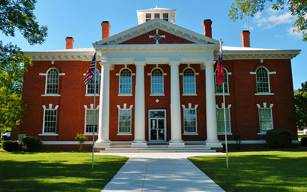 Webster County Courthouse with red-brick façade, white columns and front lawn in Preston, Georgia
