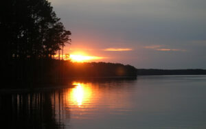 Sunset reflecting across Clarks Hill Lake beside a tree-lined shoreline in Lincoln County, Georgia.