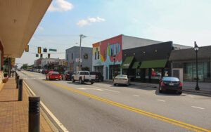 Main Street storefronts, sidewalks, parked cars, and public streetscape in downtown College Park, Georgia