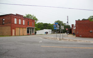 Downtown intersection with historic brick buildings and highway signs in Siloam, Georgia