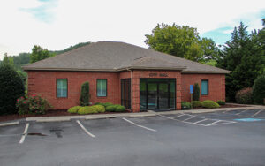 Red brick East Ellijay City Hall with parking spaces and landscaped shrubs in East Ellijay, Georgia