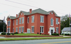 Red brick Glascock County Courthouse beside the roadway in Gibson, Georgia