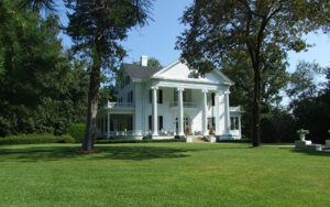White columned Hickory Hill historic home surrounded by trees and a broad lawn in Thomson, Georgia.