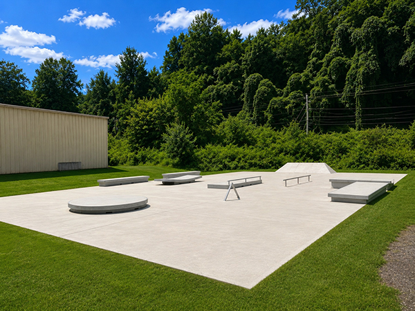 Wide overview of the concrete skate park with rails, ledges and bank features at Mark Watson Park in Sylva, North Carolina