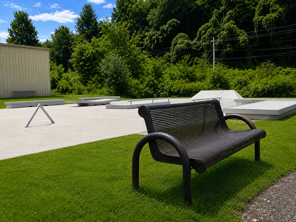 Black metal bench overlooking the rails, ledges and bank at the Jackson County skate park in Sylva, North Carolina