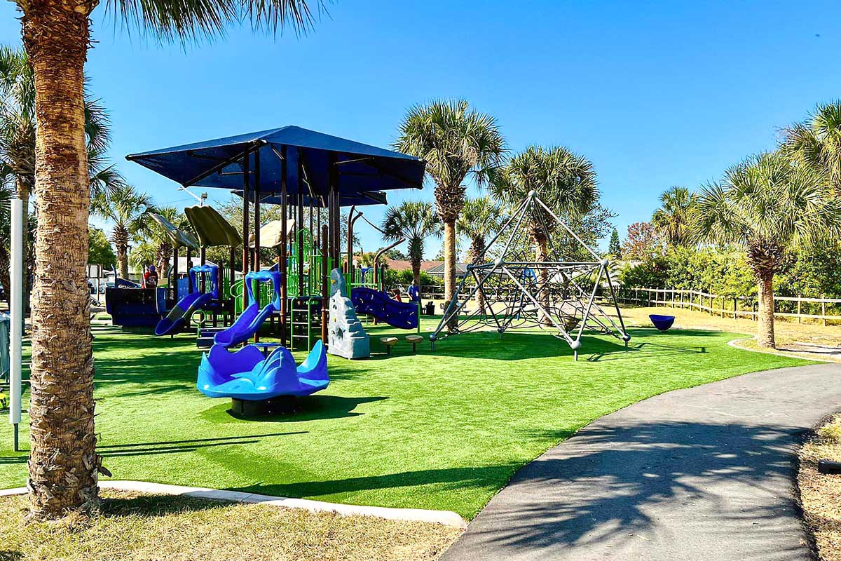 Inclusive playground and paved pathway at Lake Lisa Park in Port Richey, Florida