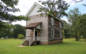 Historic wooden Council House surrounded by lawn and trees at New Echota in Gordon County, Georgia