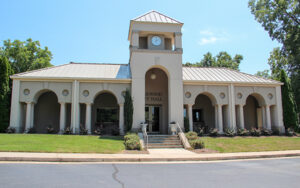 Oakwood City Hall with arched entrances, clock tower, front steps, and landscaped grounds in Oakwood, Georgia