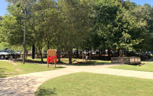 Walking paths, lawn, trees, playground equipment, and footbridge at Olde Rope Mill Park in Woodstock, Cherokee County, Georgia