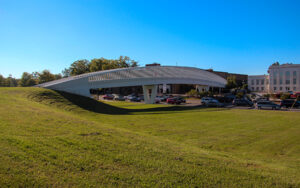 Curved pedestrian bridge above a roadway and grassy slope in Gainesville, Georgia