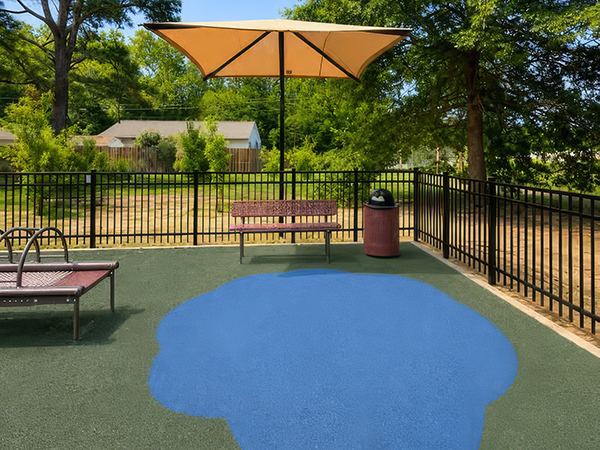 Bench beneath a shade canopy beside the playground at Wills Memorial Park in La Plata, Maryland