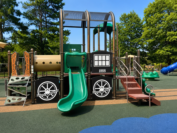 Train-themed play structure with green slide and climbing panels at Wills Memorial Park in La Plata, Maryland