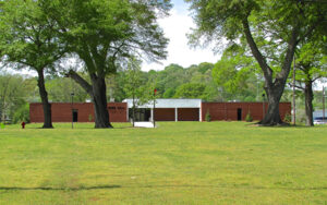 Trion Town Hall in Georgia with a wide lawn, large shade trees, and wooded ridge in the background